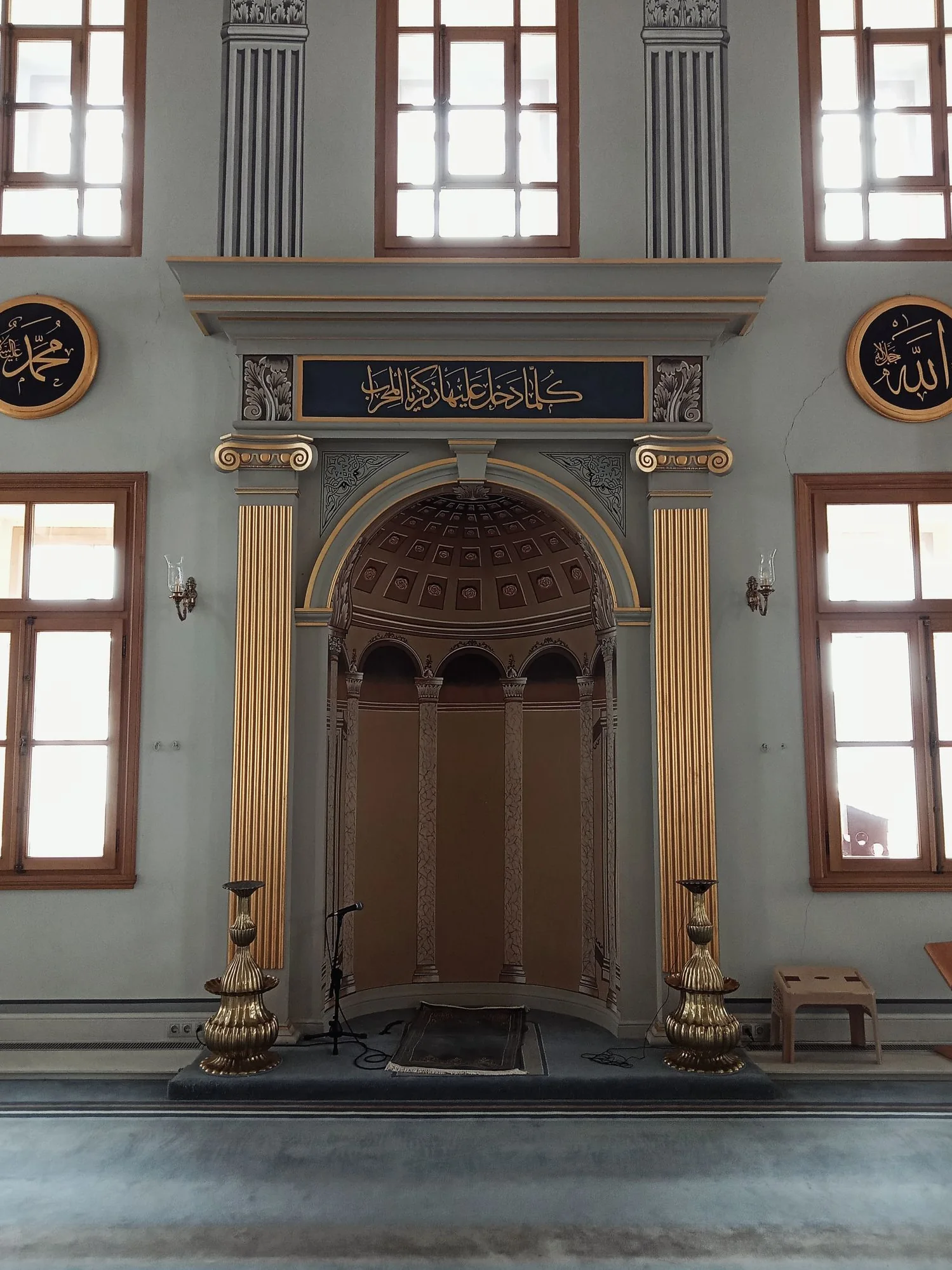 A mosque mihrab niche framed by gilded columns and calligraphy